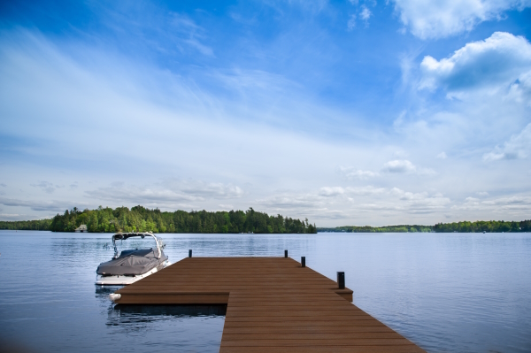 Cottage lake view with boat docked on a wooden pier in Muskoka,