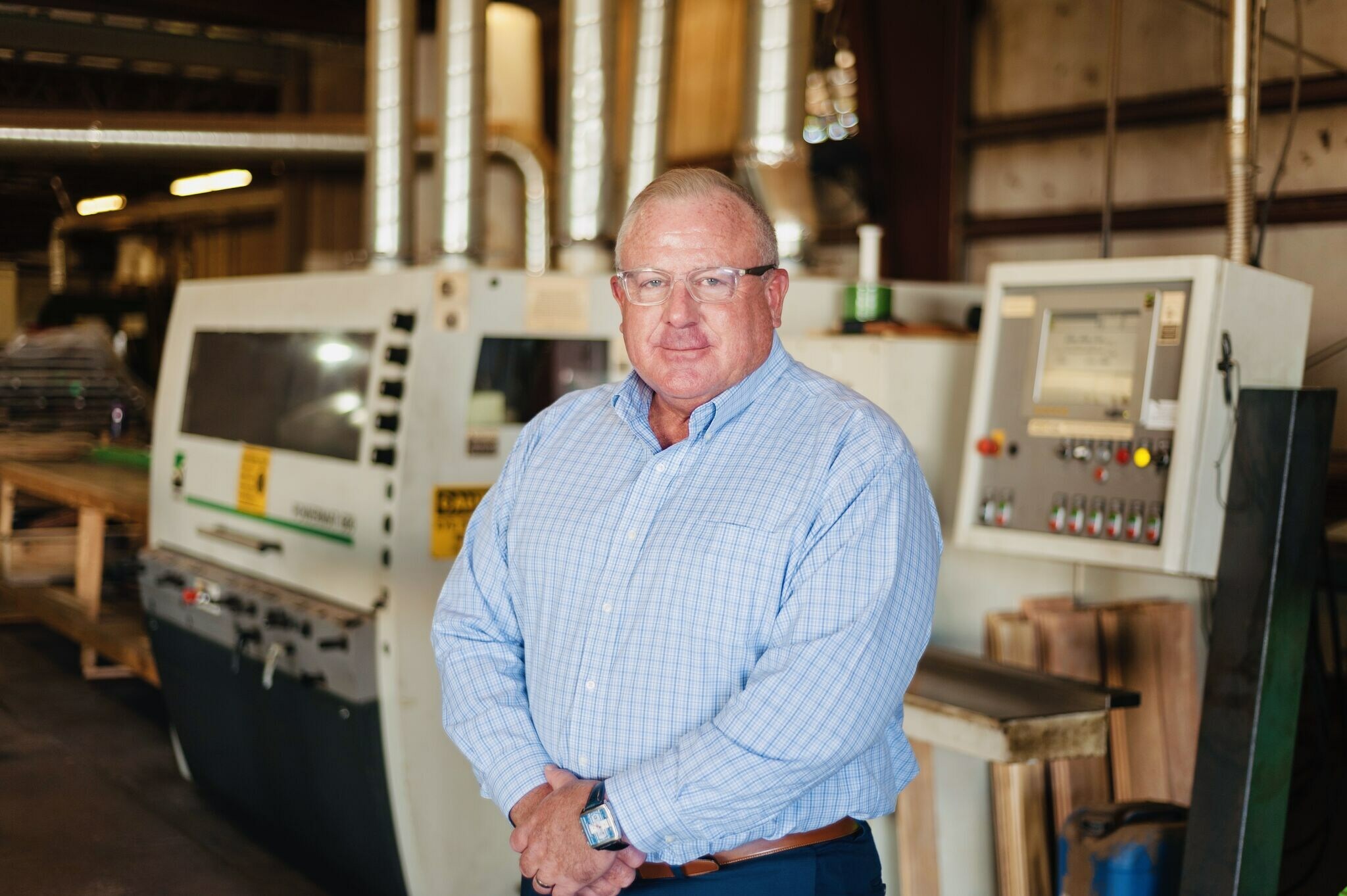 Bruce Hardt stands before a computer-controlled wood moulder capable of milling millions of square feet of hardwood flooring, trim and more.